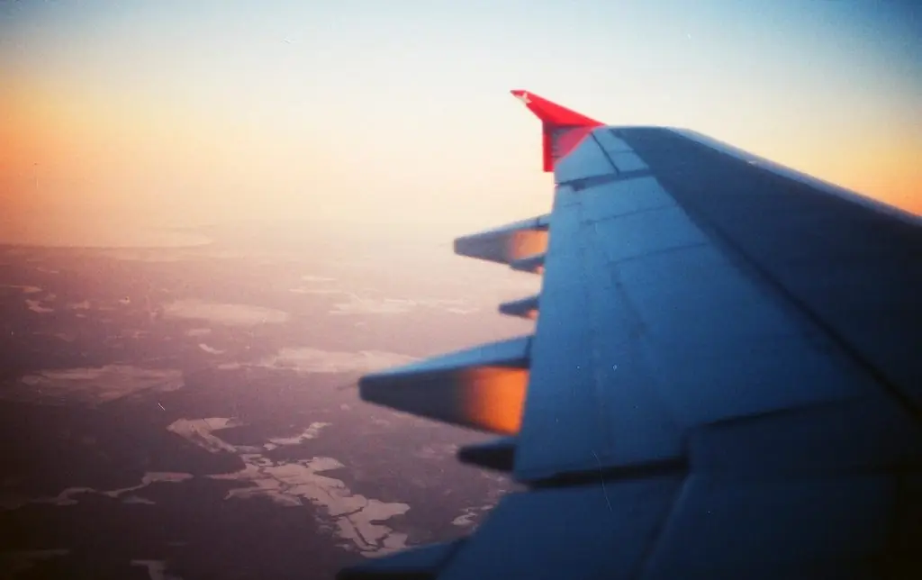 Ala de un avión al atardecer sobre las nubes
