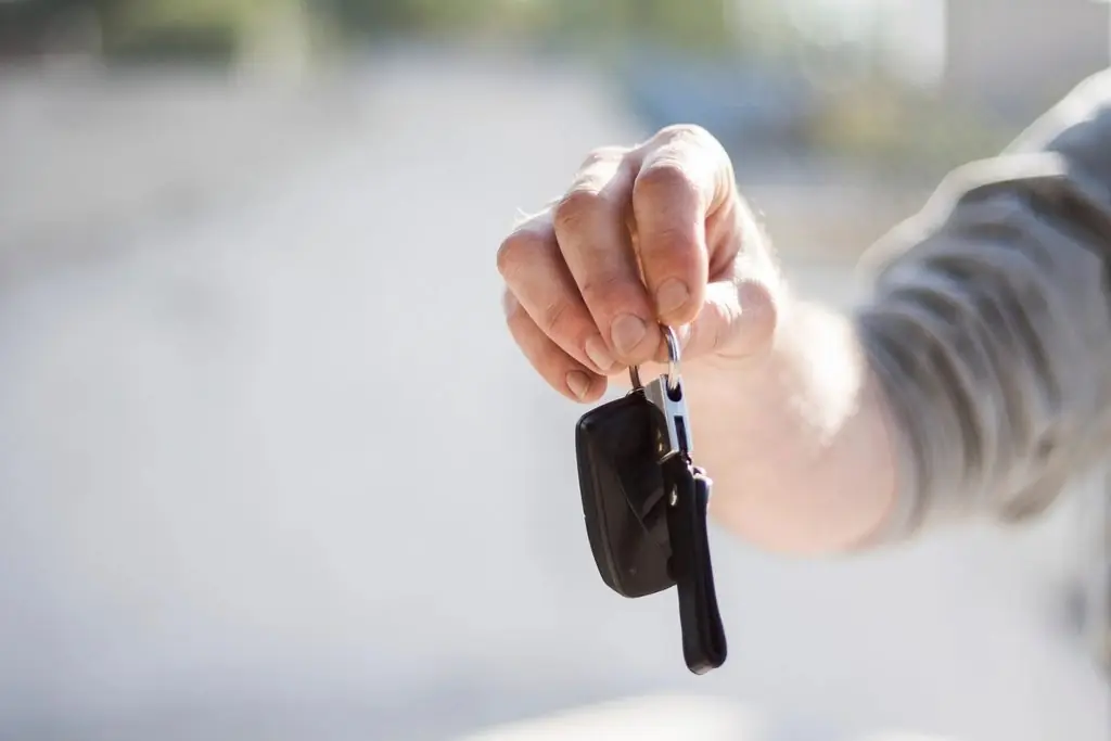 Mano sosteniendo la llave de un carro